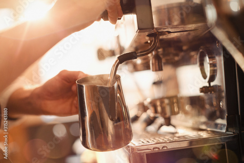 Close up barista using espresso machine milk frother photo