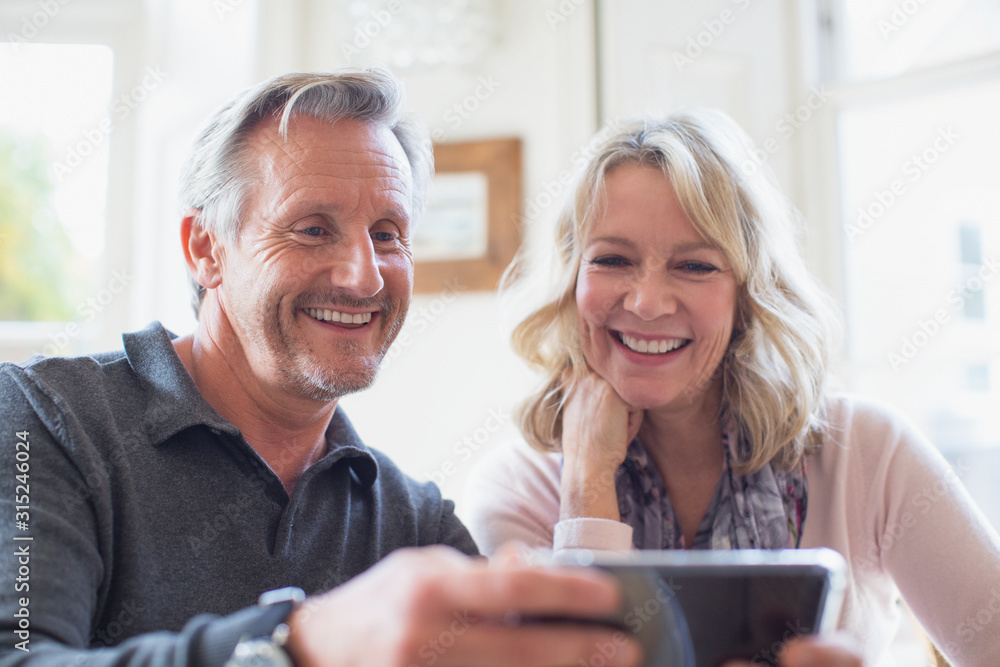 Smiling mature couple using smart phone Smiling mature couple using smart phone