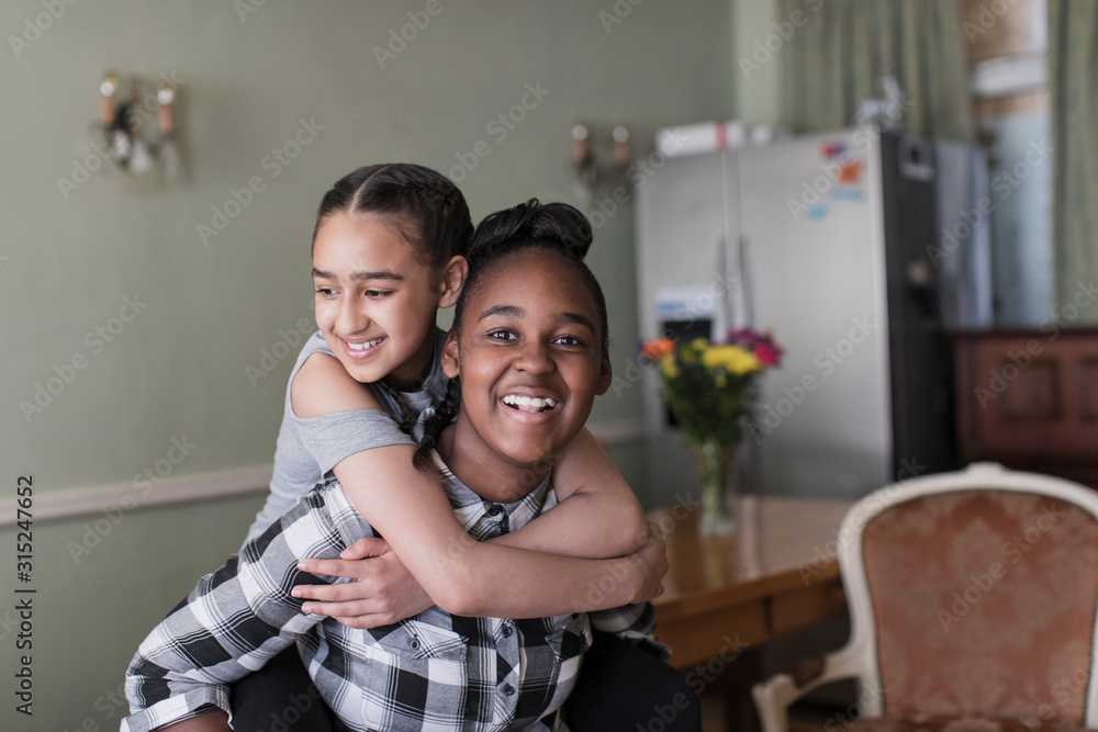 © Sam Edwards/Caia Image - Portrait happy teenage girl friends piggybacking