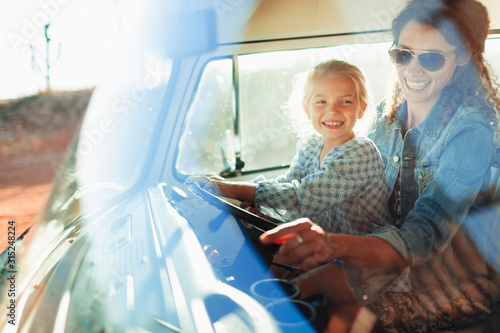 Happy mother and daughter driving van photo