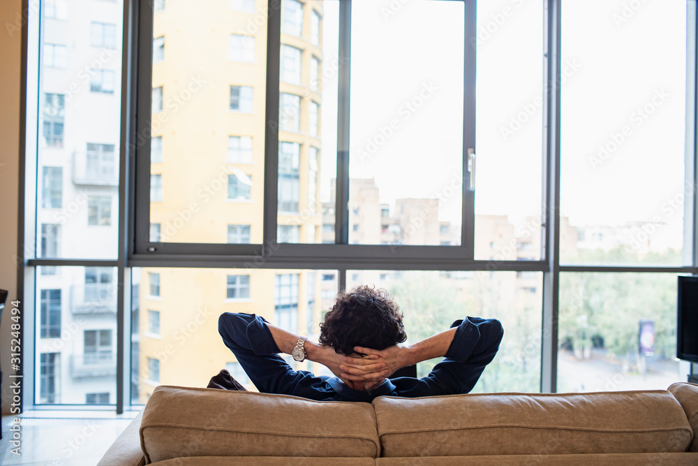 Man relaxing on urban apartment sofa