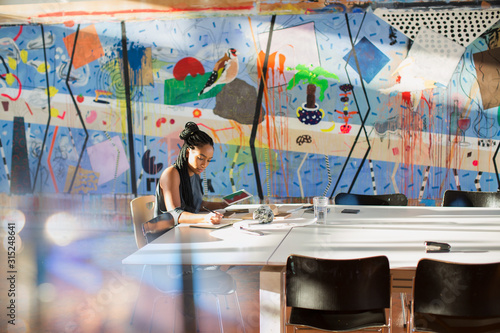 Dedicated, creative businesswoman with digital tablet working in conference room