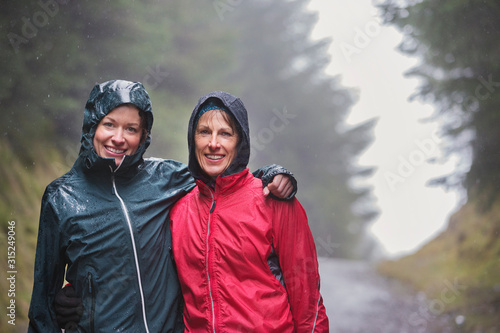 Portrait mother and daughter hiking in rain