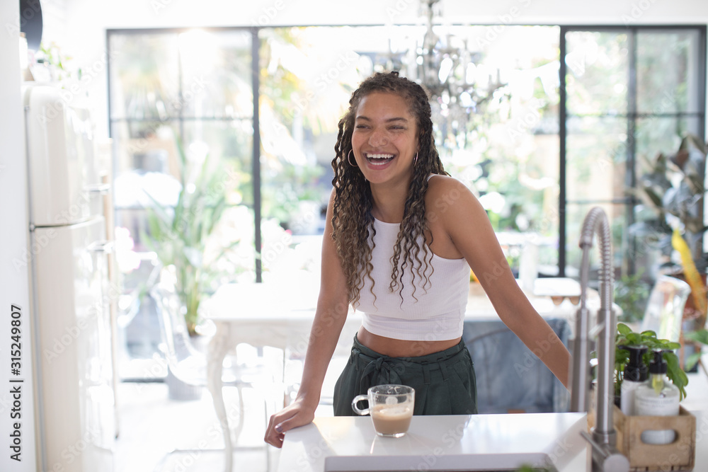 Happy young woman laughing in kitchen Happy young woman laughing in kitchen