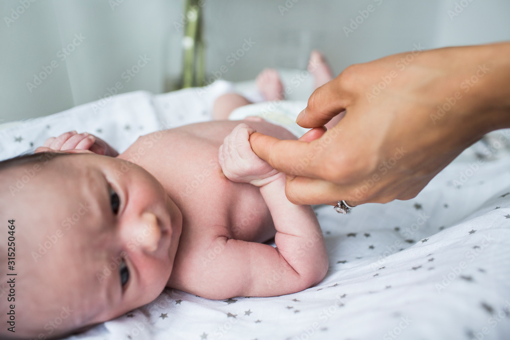 Close up mother holding hands with newborn baby son Close up mother holding hands with newborn baby son