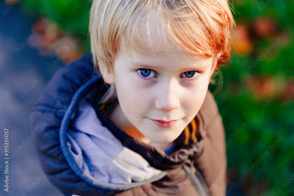 Portrait confident boy with blond hair and blue eyes Portrait confident boy with blond hair and blue eyes