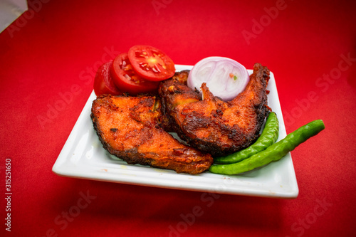 Fried carp fish in oil. Restaurant dishes. Top view. on Red background.