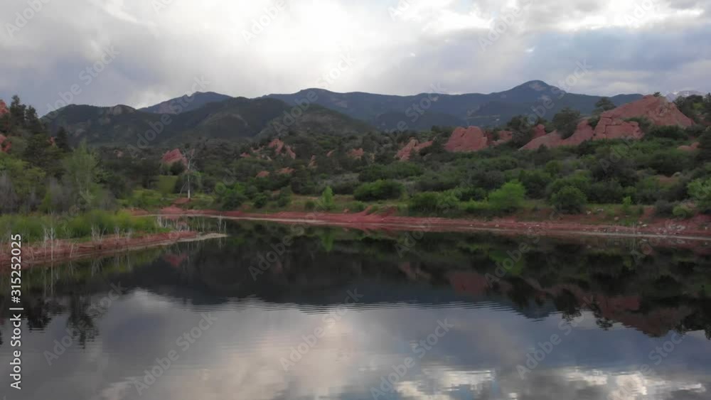 Low aerial flight over Red Rocks pond, reflecting an overcast sky Low aerial flight over Red Rocks pond, reflecting an overcast sky