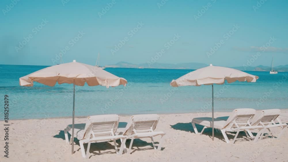 Umrellas and sunbeds prepared on the beach of Balearic island Formentera Umrellas and sunbeds prepared on the beach of Balearic island Formentera