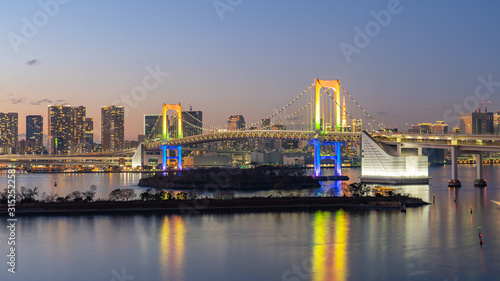 Tokyo city skyline at night with view of Rainbow bridge in Japan
