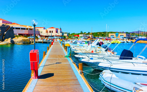 Old Sardinian Port and marina with ships at Mediterranean Sea in city of Villasimius in South Sardinia Island Italy in summer. Cityscape with Yachts and boats