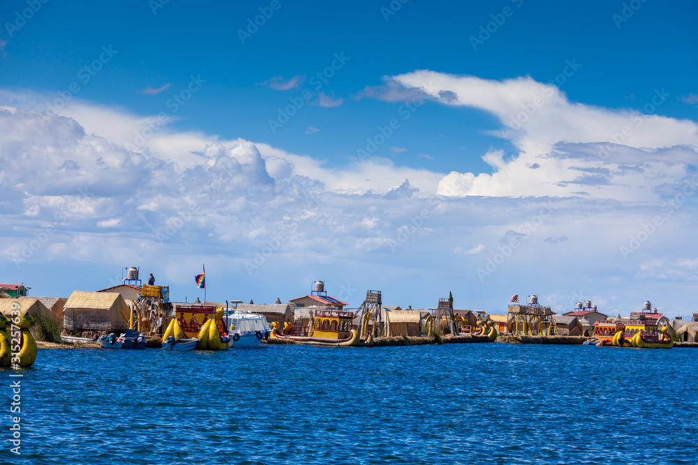 View of the floating islands of Uros, at a distance, clouds, on Lake Titicaca in Peru, South America.