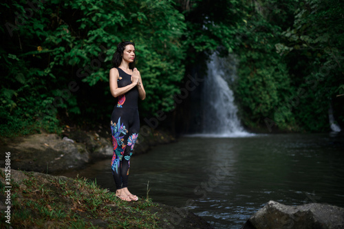 Fototapeta Naklejka Na Ścianę i Meble -  Yoga practice and meditation in nature. Woman practicing near river