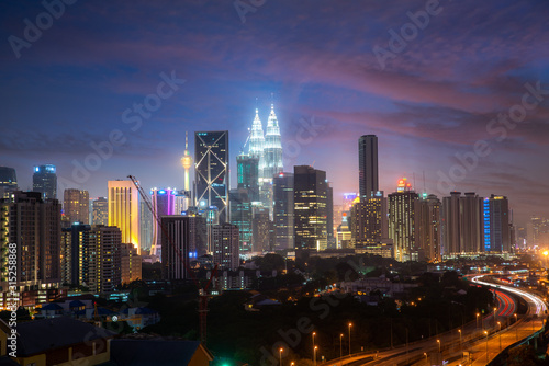 Kuala Lumpur City skyline and skyscraper with highway road at night in Kuala Lumpur, Malaysia. Asia. Malaysia tourism, modern city life, or business finance and economy concept