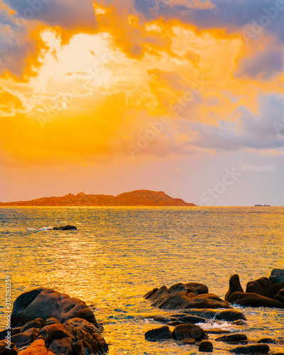 Landscape with Romantic sunset at Capriccioli Beach in Costa Smeralda of the Mediterranean sea on Sardinia island in Italy. Sky with clouds. Porto Cervo and Olbia province. Mixed media.