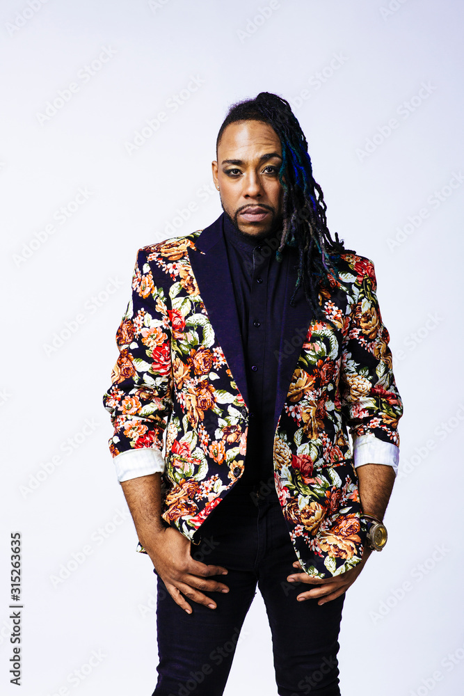 Studio portrait of a man wearing a flower patterned suit and dreadlocks Studio portrait of a man wearing a flower patterned suit and dreadlocks