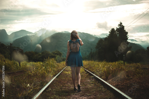 woman walking on railroad