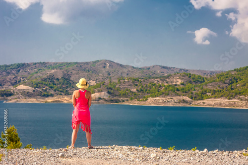 girl in a pink dress admires a calm lake © Kooper