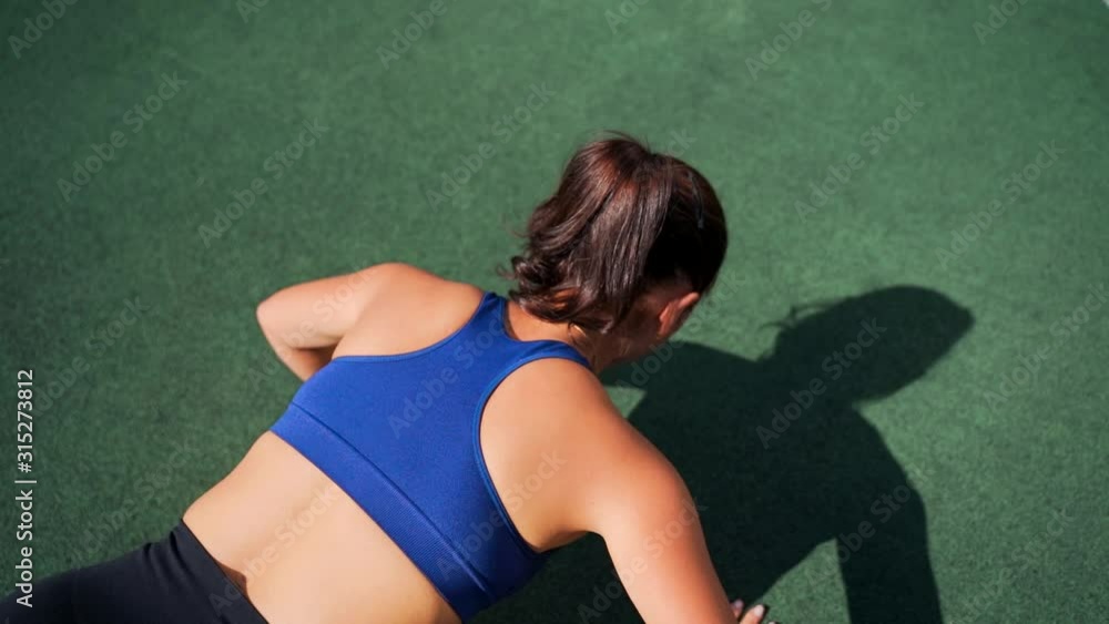 Fitness Girl Doing Push Up Exercises. She is Doing a Workout in a Fenced Outdoor Basketball Court. Fitness Girl Doing Push Up Exercises. She is Doing a Workout in a Fenced Outdoor Basketball Court.