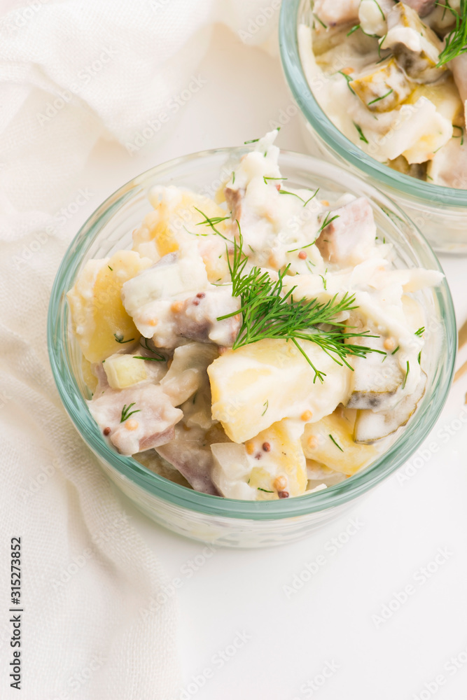 Salad rasols made of herring, cucumber and potato, dressed with mayonnaise and mustard