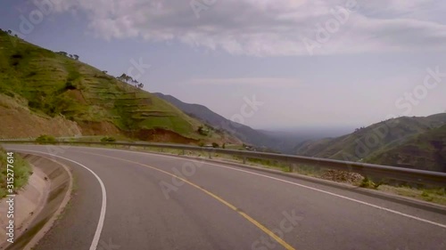 View from a vehicle moving on the curvaceous mountain roads amidst beautiful mountains and valley. photo