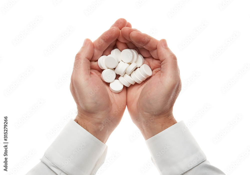 Man hand with handful of big white pills isolated on white background. White shirt, business style. Medicament and food supplement for health care. Pharmaceutical industry. Pharmacy. Man hand with handful of big white pills isolated on white background. White shirt, business style. Medicament and food supplement for health care. Pharmaceutical industry. Pharmacy.