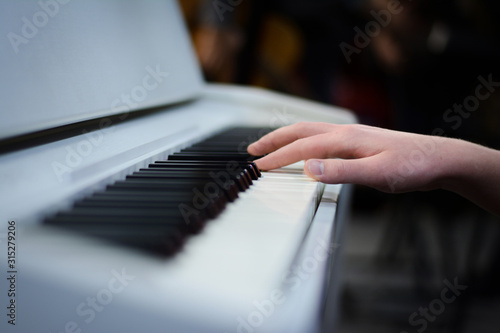 hand playing piano, white piano keys, black and white keys and hand
