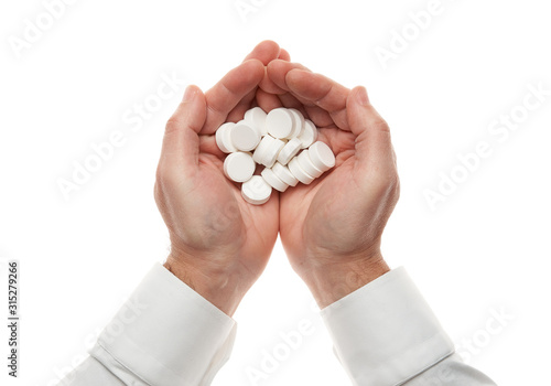 Man hand with handful of big white pills isolated on white background. White shirt, business style. Medicament and food supplement for health care. Pharmaceutical industry. Pharmacy.