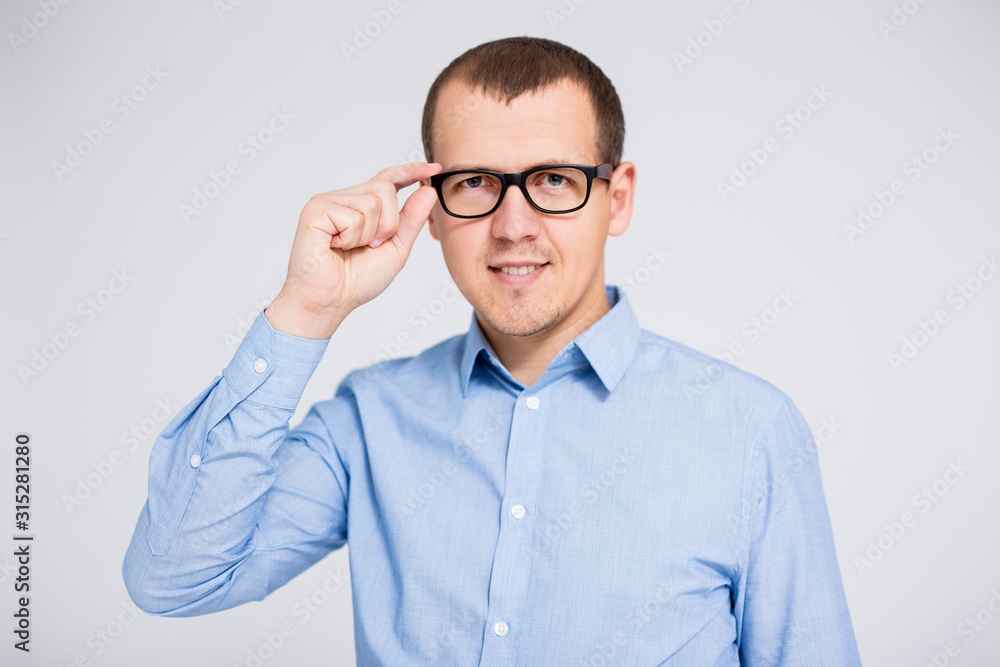 businessman in eyeglasses looking at camera over gray background businessman in eyeglasses looking at camera over gray background