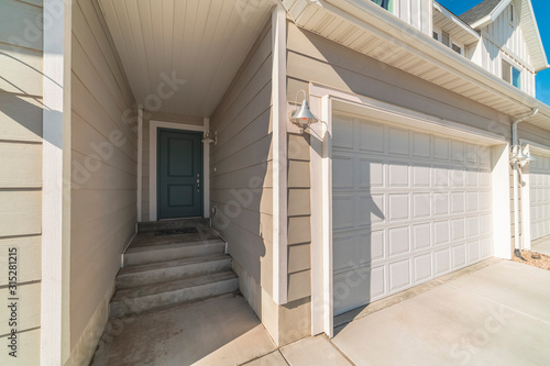 White garage door with recessed covered entrance