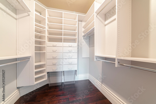 Fully fitted empty white walk-in wardrobe bright interior