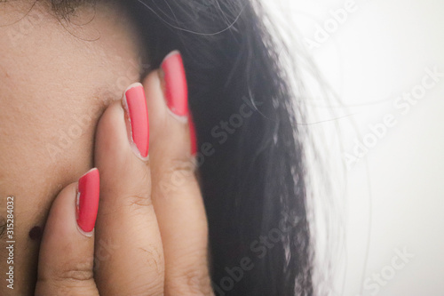 Fingers With Beautiful Red Color Painted Nails Of Indian Asian Wheatish Girl Women Lady Covering Her Eyes And Face photo