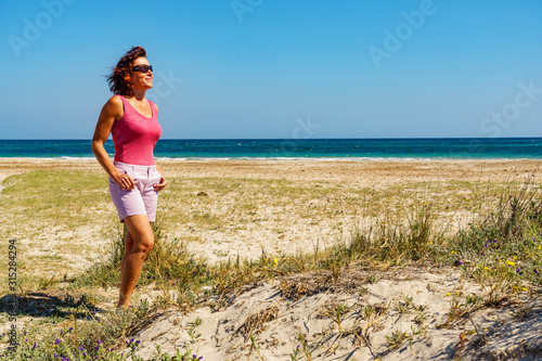 Woman walking on beach, Spain