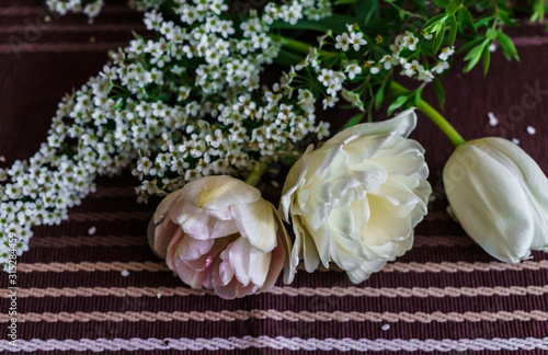 Still life of soft pink tulips with spirea twigs.