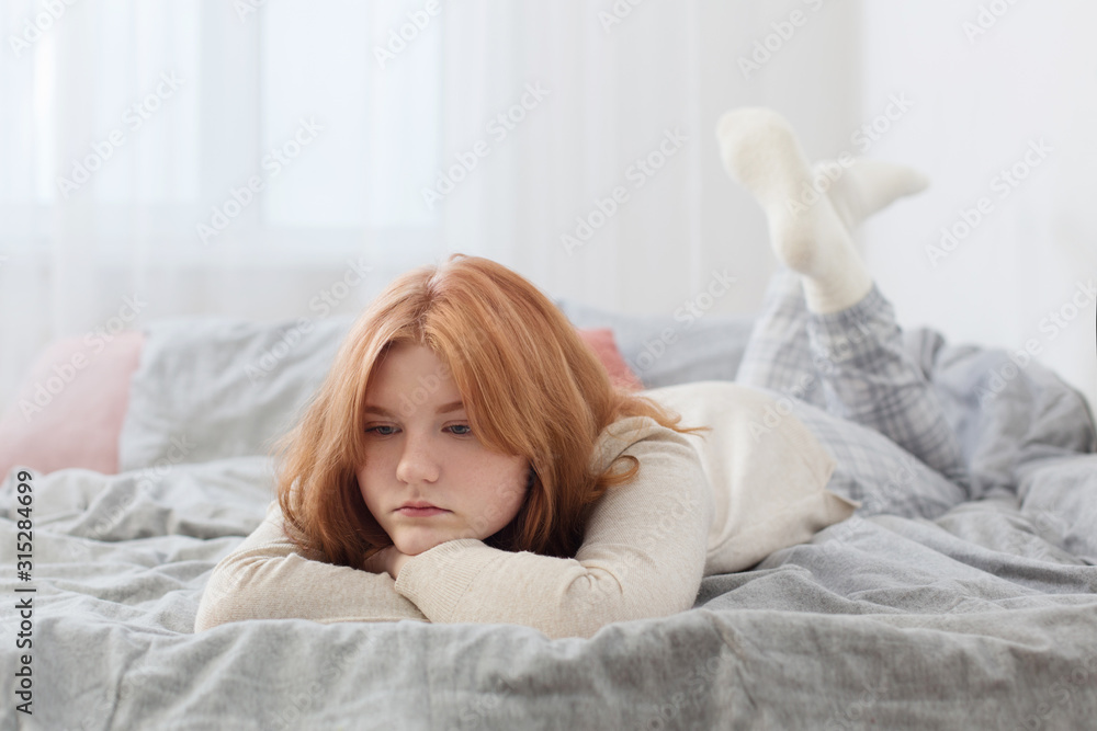 beautiful sad blonde teenager girl on bed at home beautiful sad blonde teenager girl on bed at home