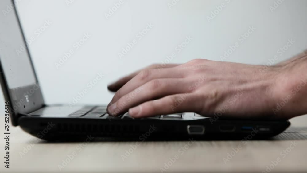 Close up of the hands typing on laptop keyboard .A man sitting in a office and working on a computer. Close up of the hands typing on laptop keyboard .A man sitting in a office and working on a computer.