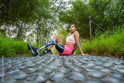Leg amputated Asian girl posing with confident after her workout routine in nature park