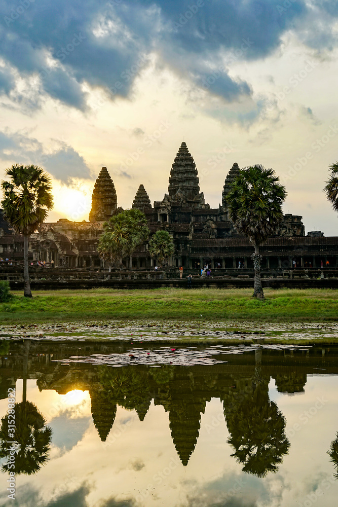 Angkor Wat, reflection of an ancient temple in the lake, dawn, morning sun, vertical photo