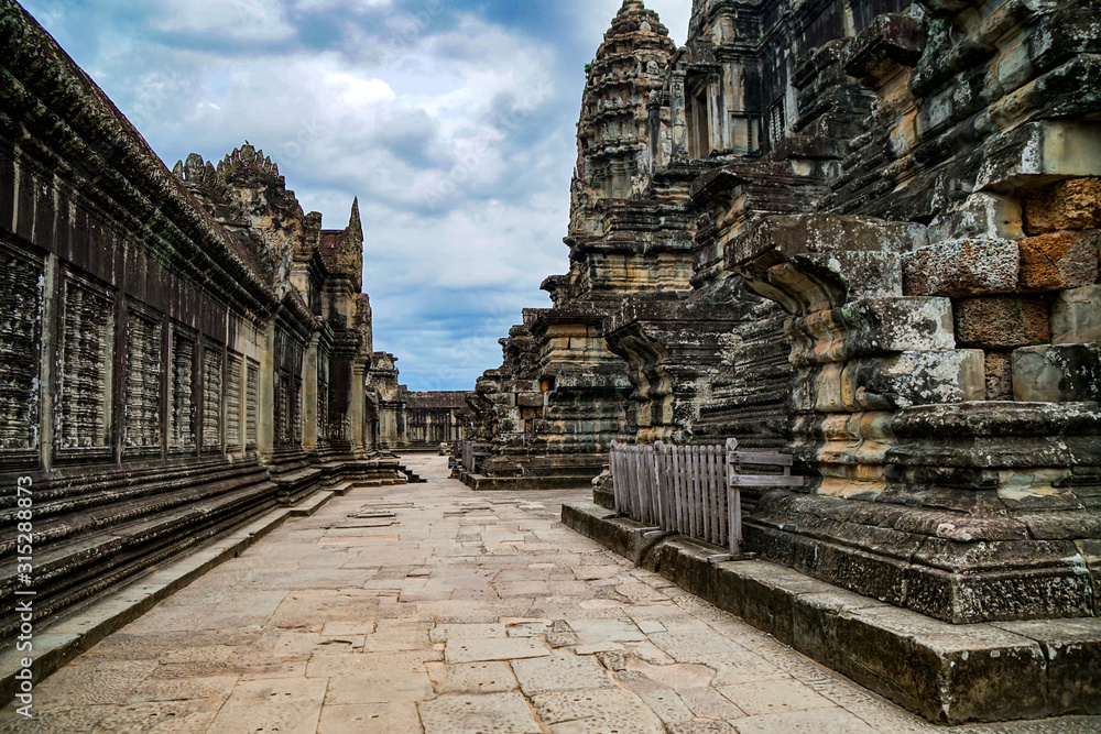 Empty area of Angkor Wat temple in Cambodia, nobody, cloudy sky and ancient walls Empty area of Angkor Wat temple in Cambodia, nobody, cloudy sky and ancient walls