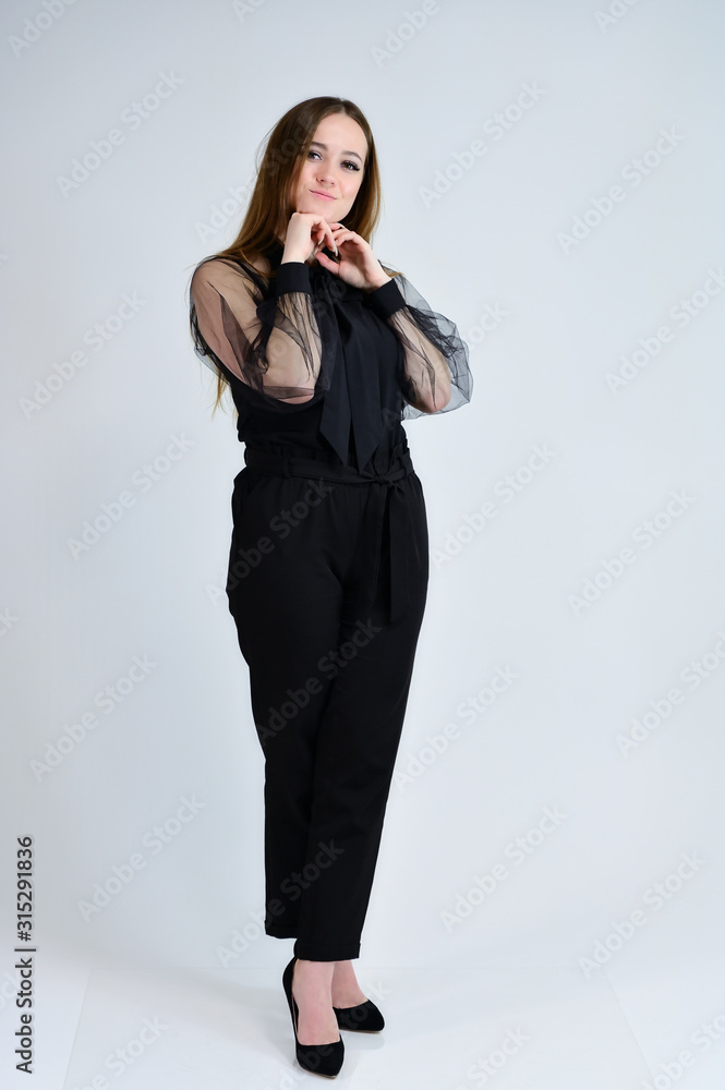 A full-length photo of a pretty smiling girl A brunette girl with excellent makeup in dark clothes is standing on a white background, talking with emotions. Concept portrait for a banner. A full-length photo of a pretty smiling girl A brunette girl with excellent makeup in dark clothes is standing on a white background, talking with emotions. Concept portrait for a banner.