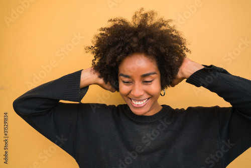 Young afro woman listening to music with headphones. © Mego-studio