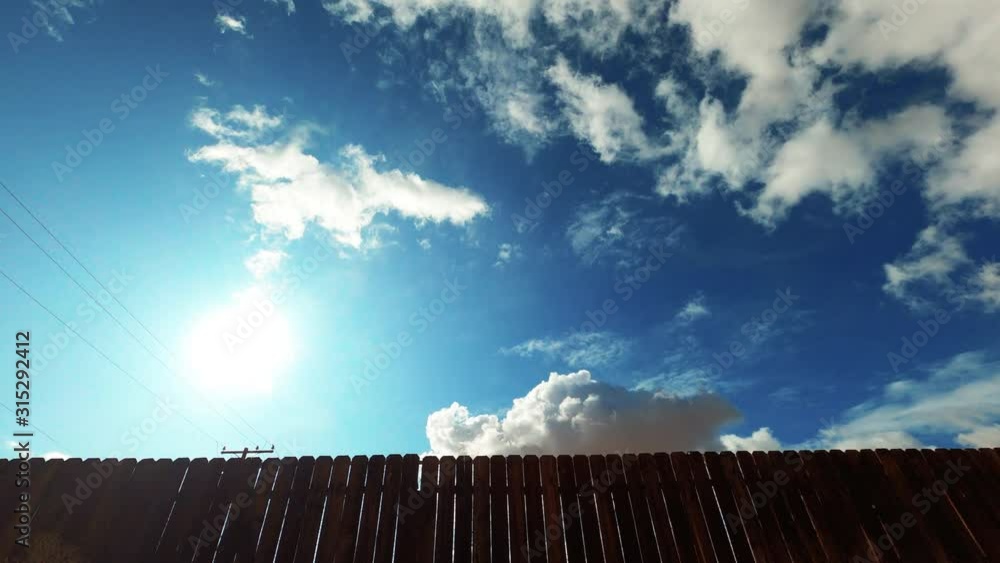 The view of clouds rolling over a wooden fence and power lines in the Mojave desert, California - Time lapse The view of clouds rolling over a wooden fence and power lines in the Mojave desert, California - Time lapse