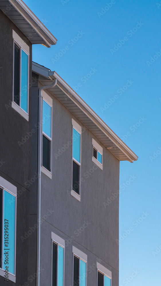 Vertical frame Facade of grey house against blue sky