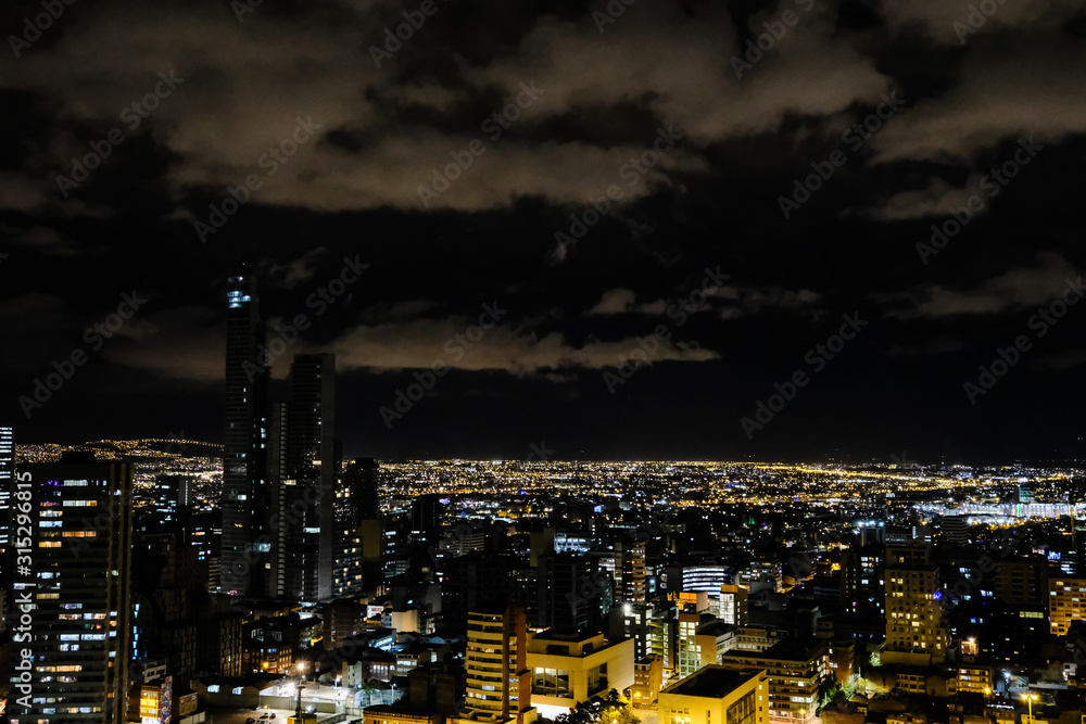View of the night city with high buildings. Bogota, Colombia. A bit cloudy.