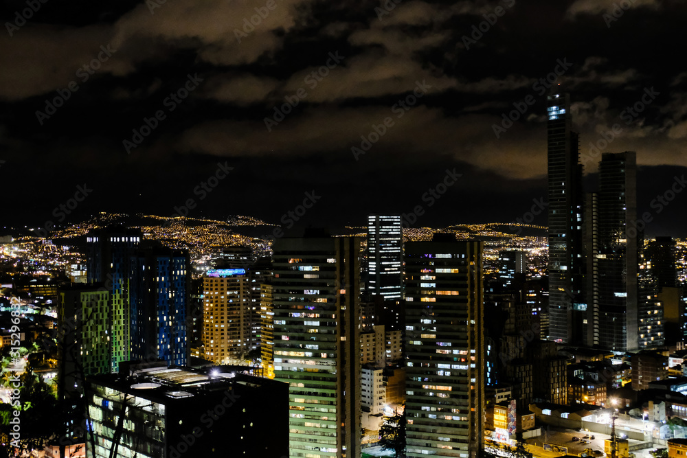 View of the night city with high buildings. Bogota, Colombia. A bit cloudy.