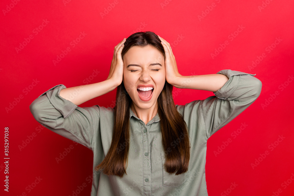 Close-up portrait of her she nice attractive devastated overwhelmed straight-haired girl wearing khaki shirt closing ears dislike bad mood isolated over bright vivid shine vibrant red color background Close-up portrait of her she nice attractive devastated overwhelmed straight-haired girl wearing khaki shirt closing ears dislike bad mood isolated over bright vivid shine vibrant red color background