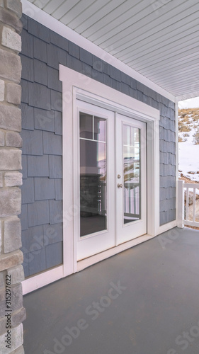 Vertical frame Glass front door to a house with covered porch