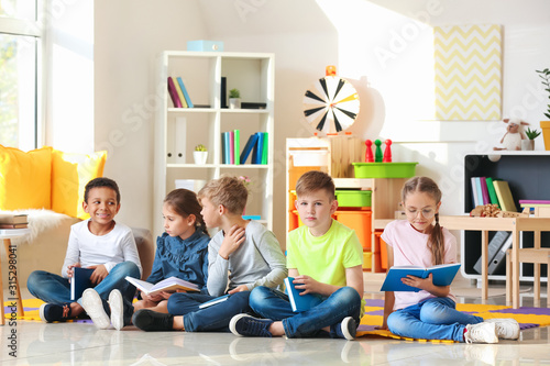 Cute little children reading books indoors