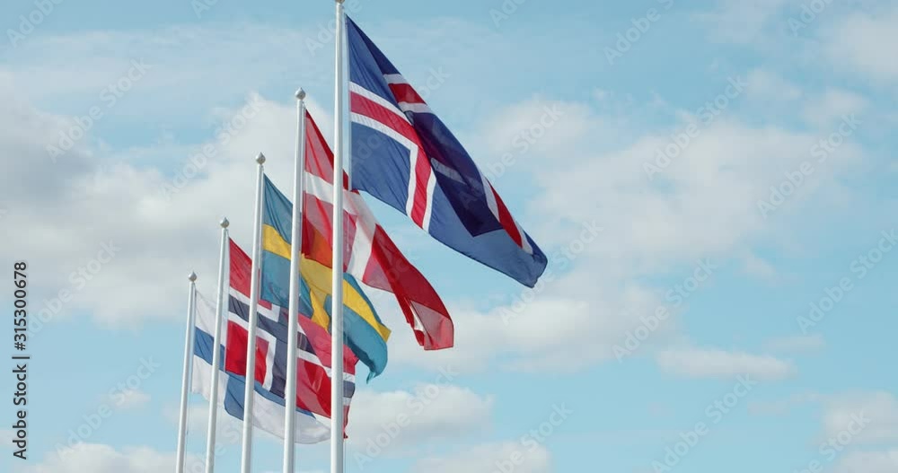 Zoom out shot of scandinavian union flags, swedish, danish, norwegian and icelandic flapping in wind on sunny summer day. Northern countrie in economic cooperation Zoom out shot of scandinavian union flags, swedish, danish, norwegian and icelandic flapping in wind on sunny summer day. Northern countrie in economic cooperation