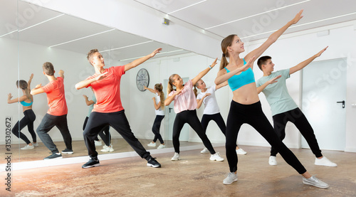 Teenage dancers practicing active vigorous dance in modern studio